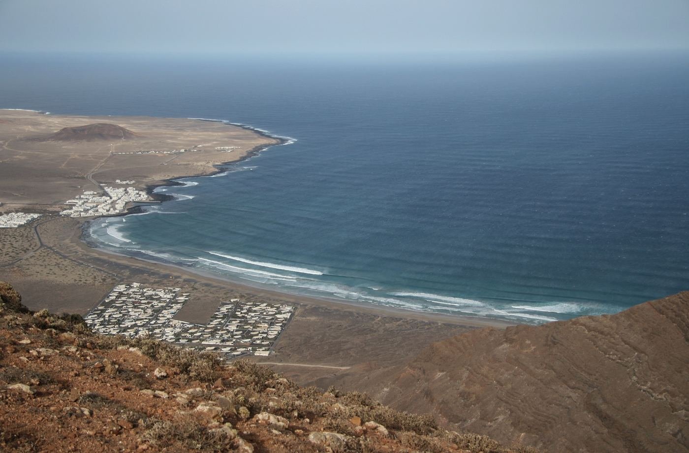 Caleta de Famara seen from the cliffs, with the long beach curving below